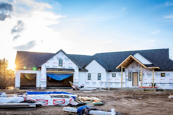 a new build detached home with roofing materials in the foreground