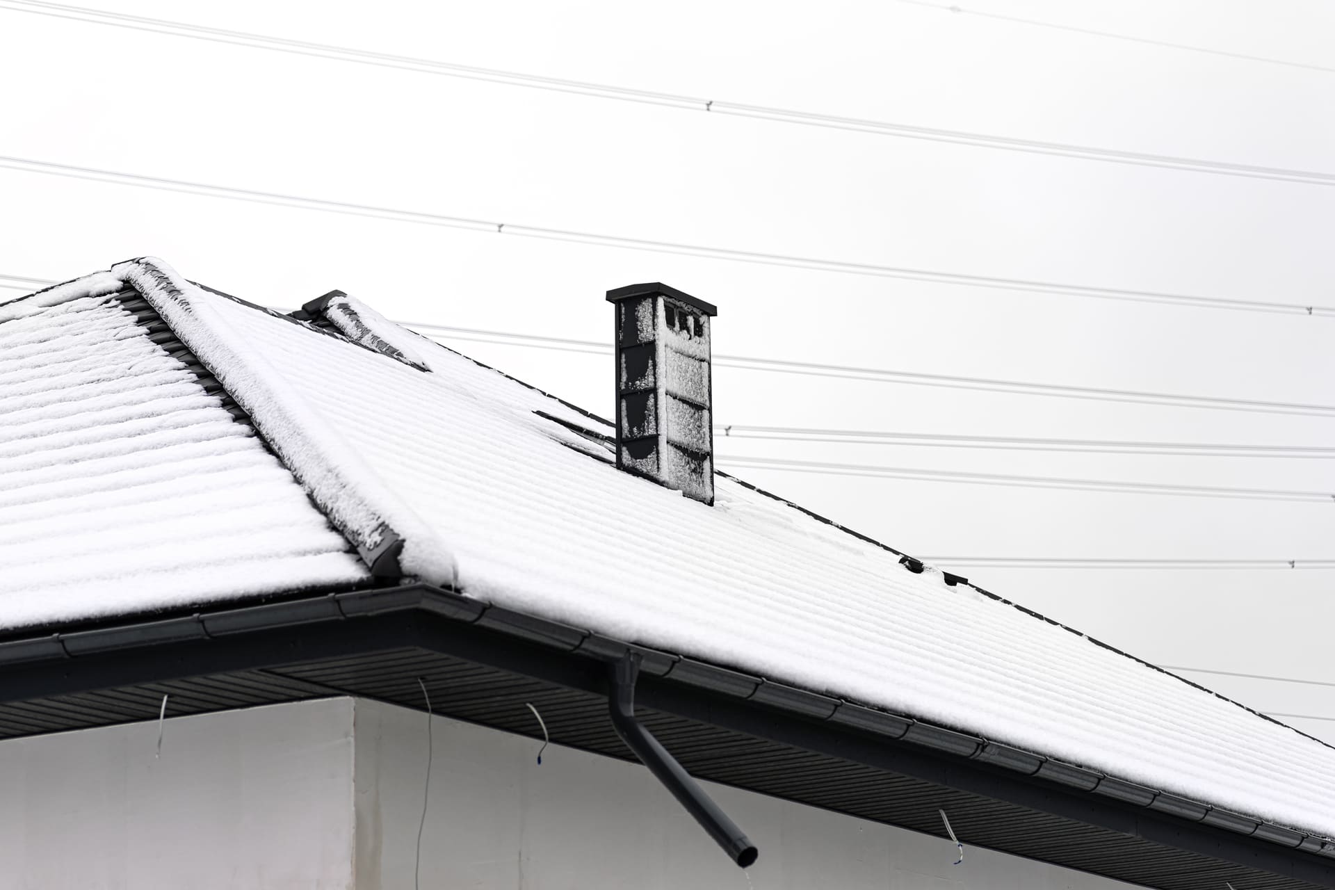 snow-covered-house-roof-with-chimney-in-winter
