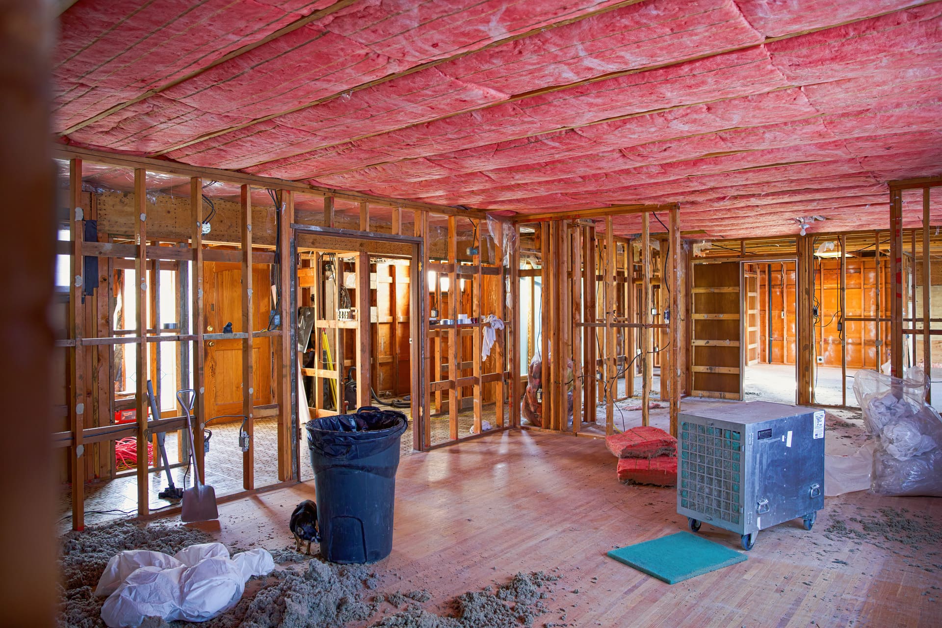 home-interior-under-renovation-with-exposed-framing-and-pink-fiberglass-insulation-on-ceiling